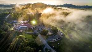 An aerial view of a resort with a central building, a circular driveway, and surrounding greenery. - Summit Rainforest Golf Resort & All Inclusive (Panama City)