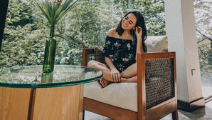 A room with a large glass window, a wooden chair, and a glass table with a plant. - Summit Rainforest Golf Resort & All Inclusive (Panama City)