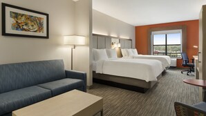A hotel room with a sofa, two beds, a desk, and a window with a view. - Holiday Inn Express & Suites Mt. Pleasant by IHG (Mount Pleasant)