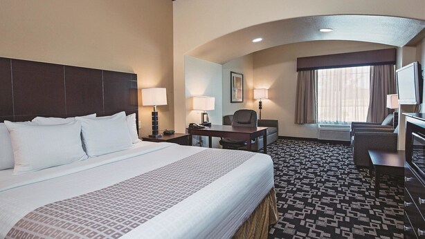A hotel room with a large bed, a desk, a chair, a television, and a window with curtains. - Motel 6 Joshua, TX (Joshua)