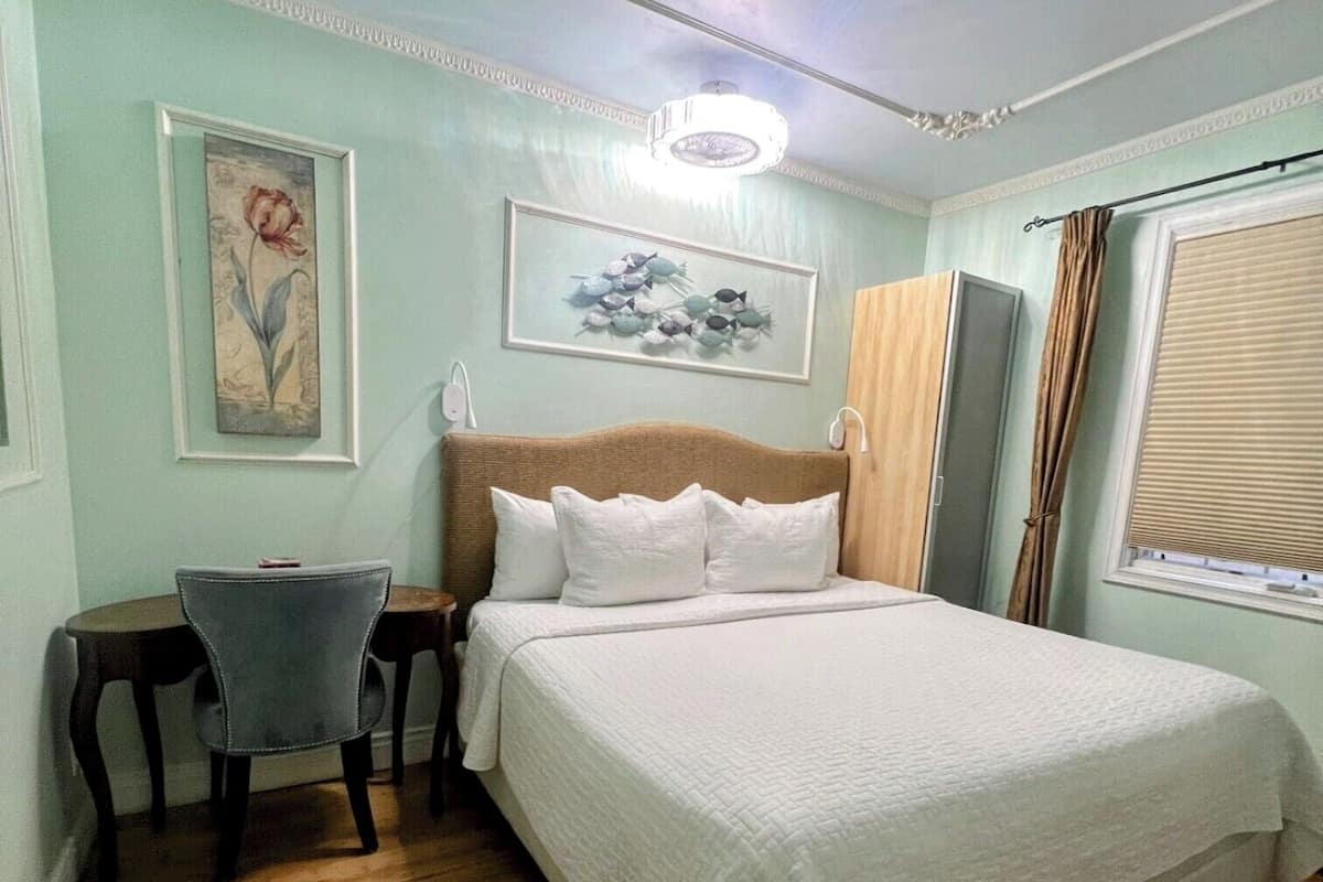 Quarto com cama, escrivaninha e cadeira.