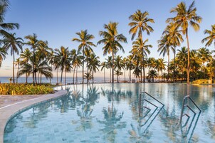 Una piscina al aire libre, sombrillas, sillones reclinables de piscina