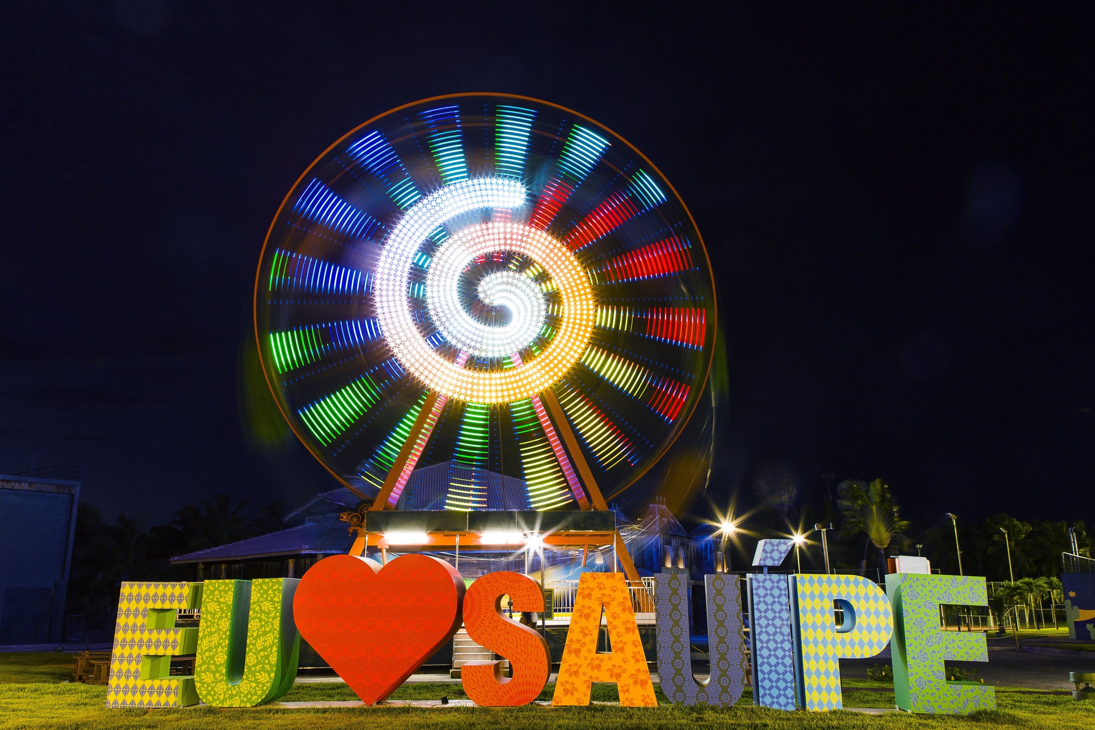 Una noria con luces de colores y las palabras 'EU SAUPE' y un símbolo de corazón.