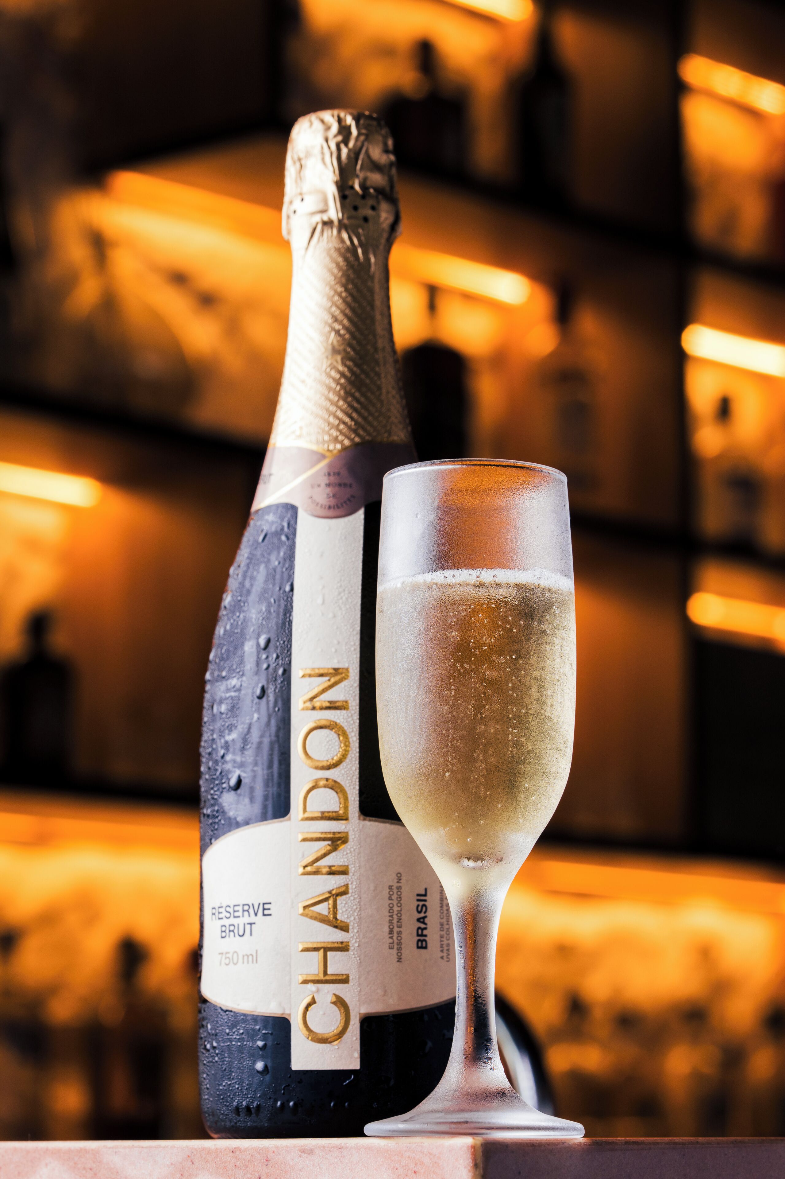A bottle of Chandon champagne and a glass of champagne.