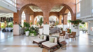 A spacious lobby with brick arches, seating areas, and potted plants. - Sauipe Brisa Grand Premium – All Inclusive (Mata de São João)