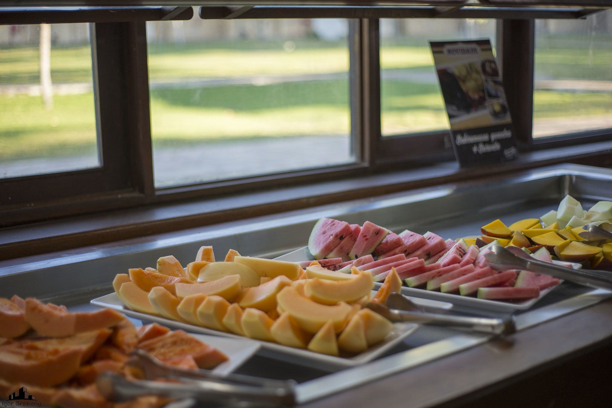 A buffet with various food items including fruits and meats.