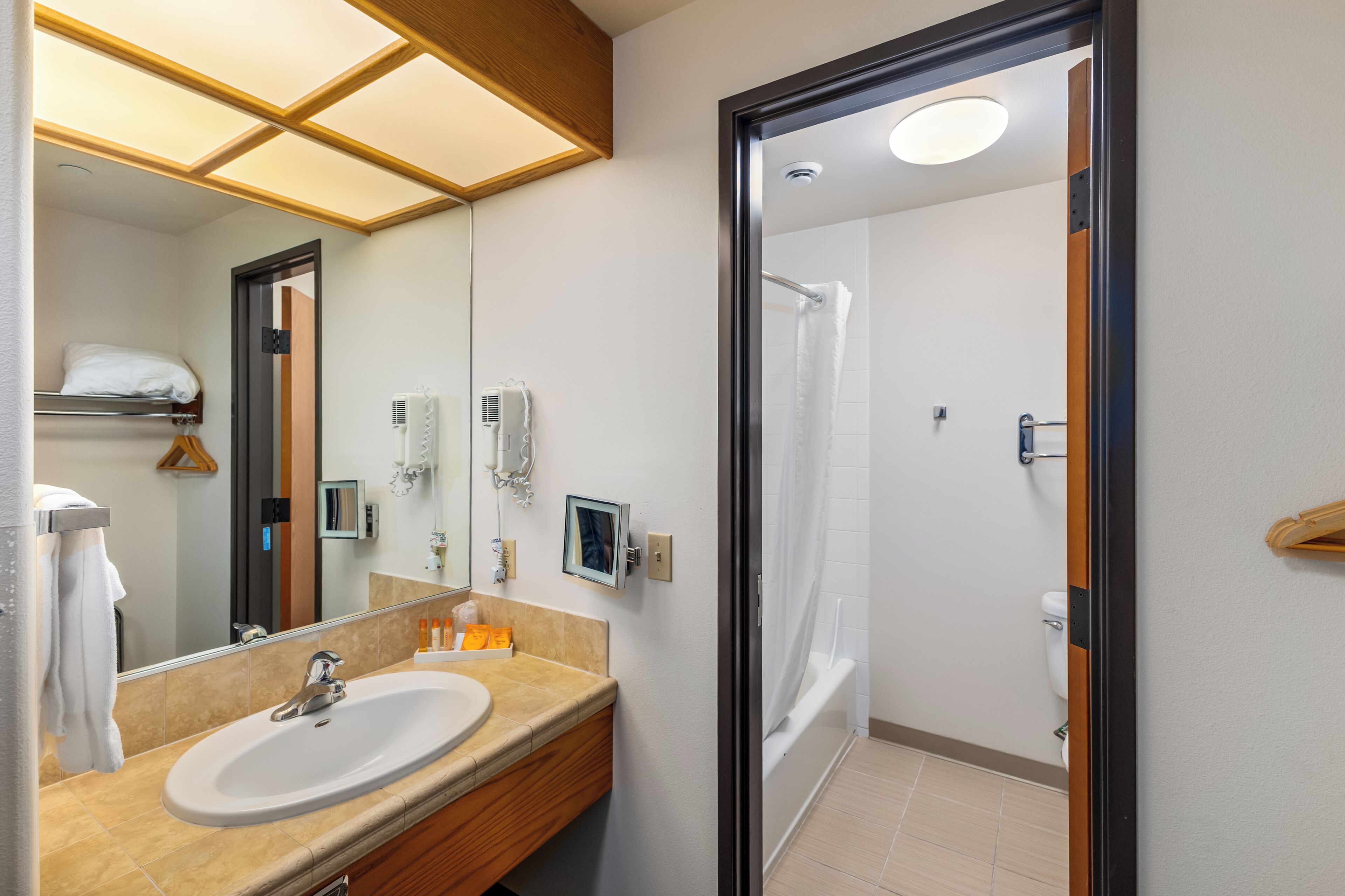 Un bagno moderno con lavandino, specchio e doccia.