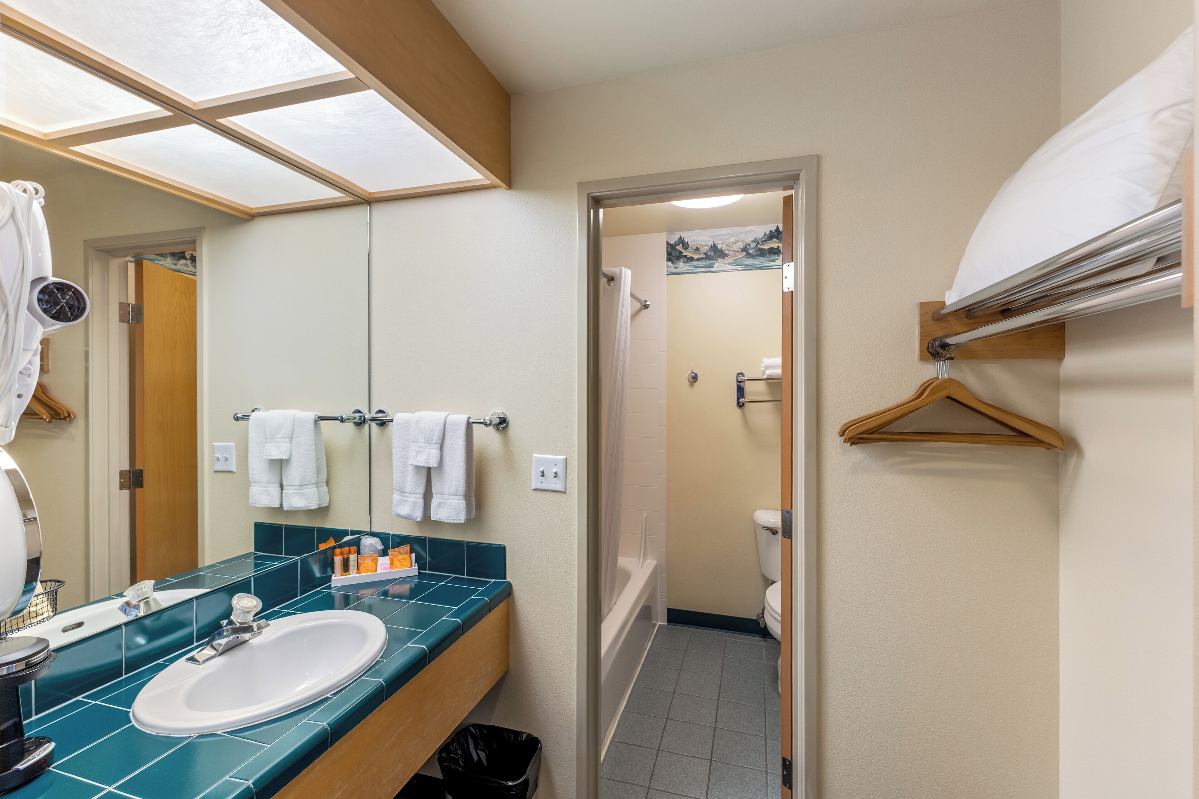 A bathroom with a sink, mirror, and towel rack.