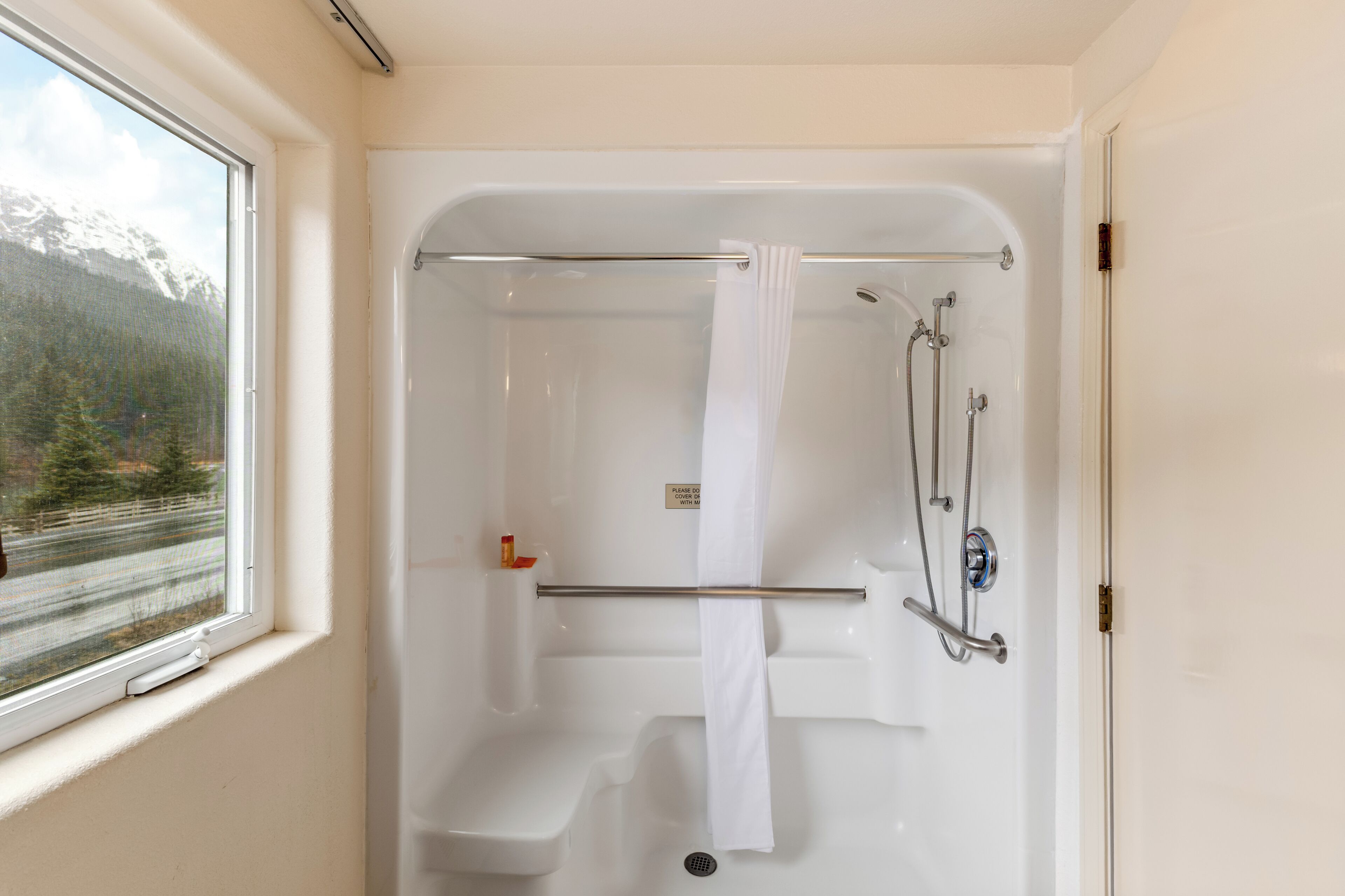 A walk-in shower with a towel rack, a showerhead, and a drain.