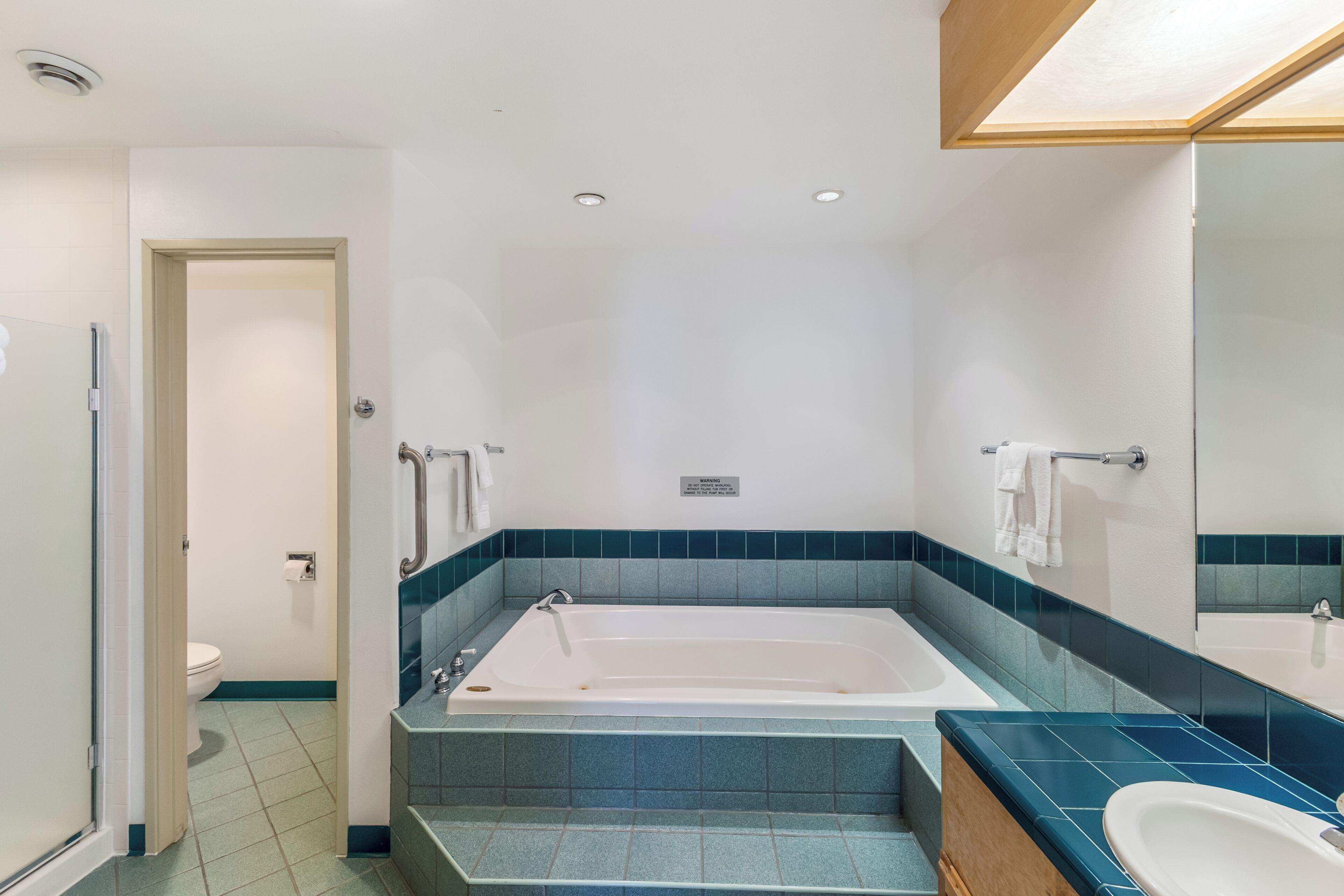 A modern bathroom with a bathtub, a sink, and a toilet.