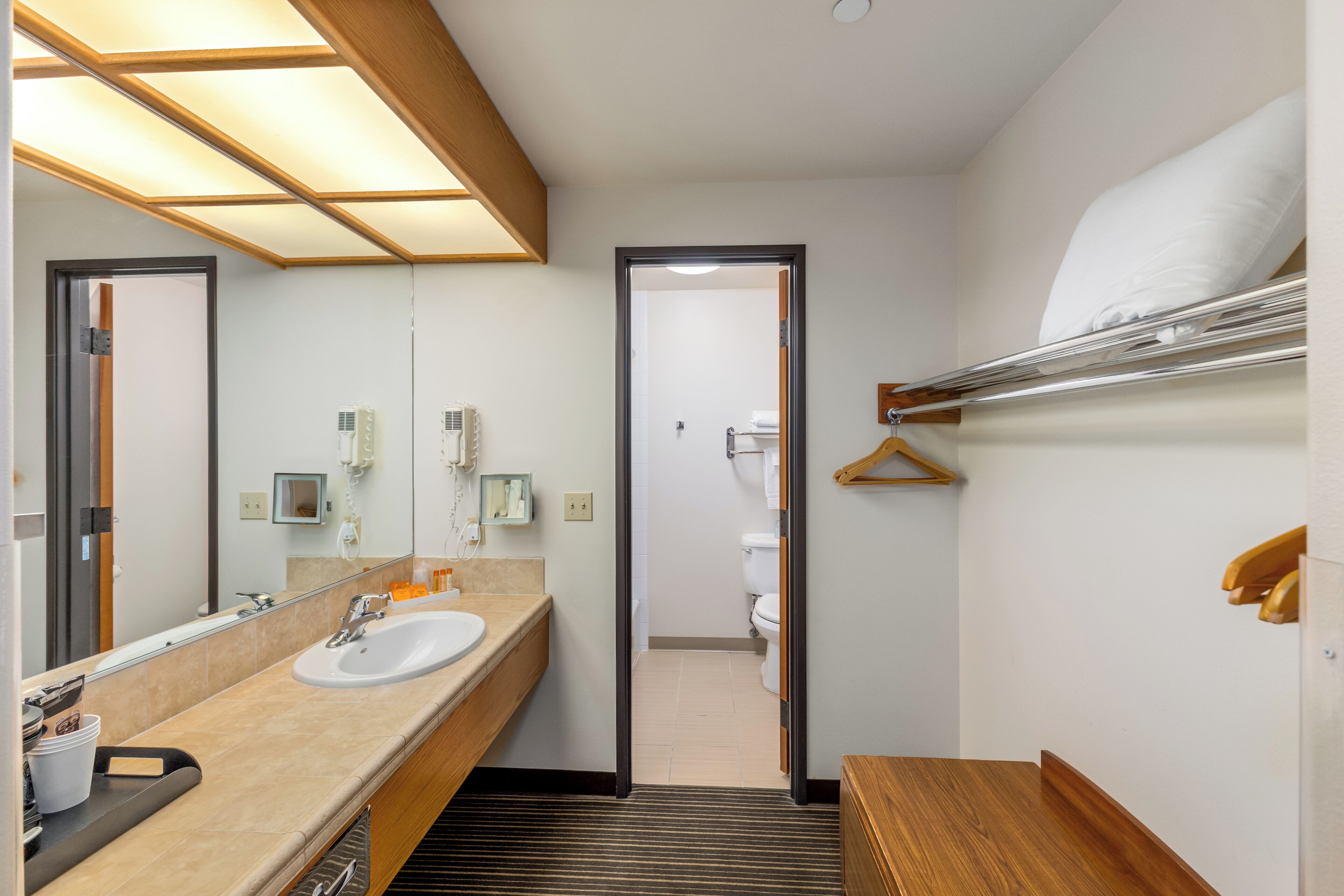 A modern bathroom with a large mirror, a sink, and a shower area.