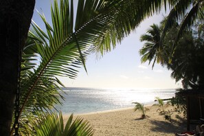 A beach with palm trees and a clear view of the ocean. - Castaway Resort (Rarotonga)