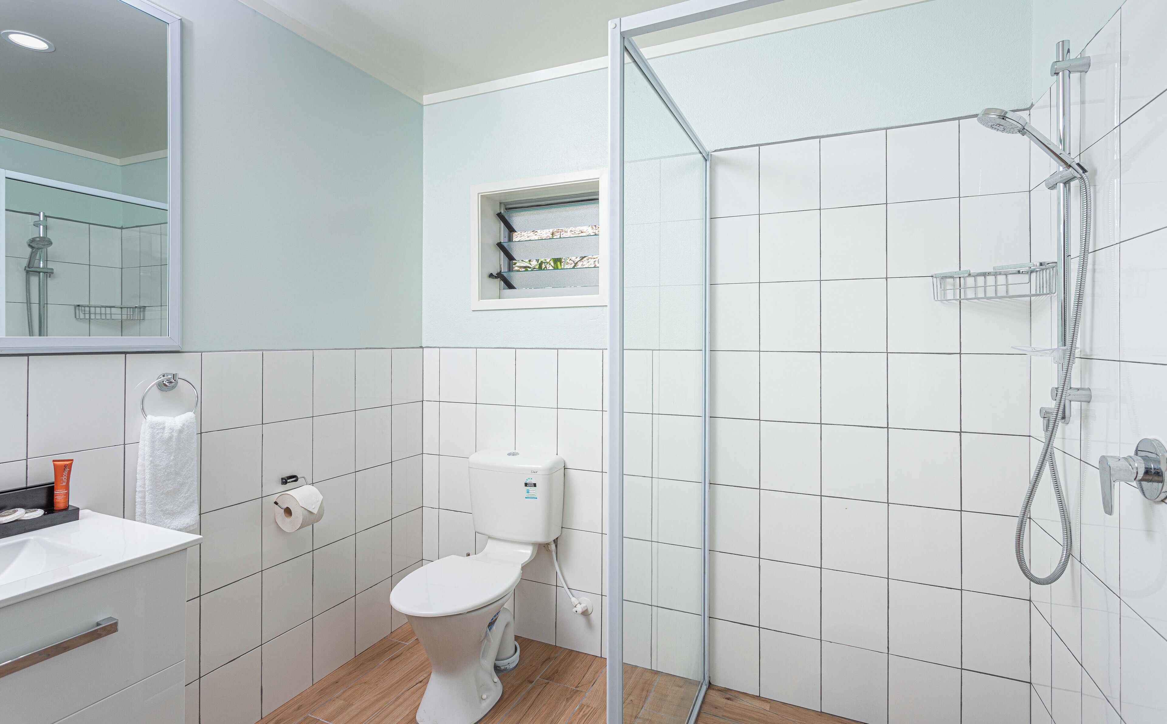 A modern bathroom with a toilet, sink, and shower.