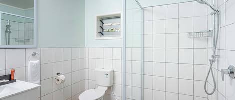 A modern bathroom with a toilet, sink, and shower.