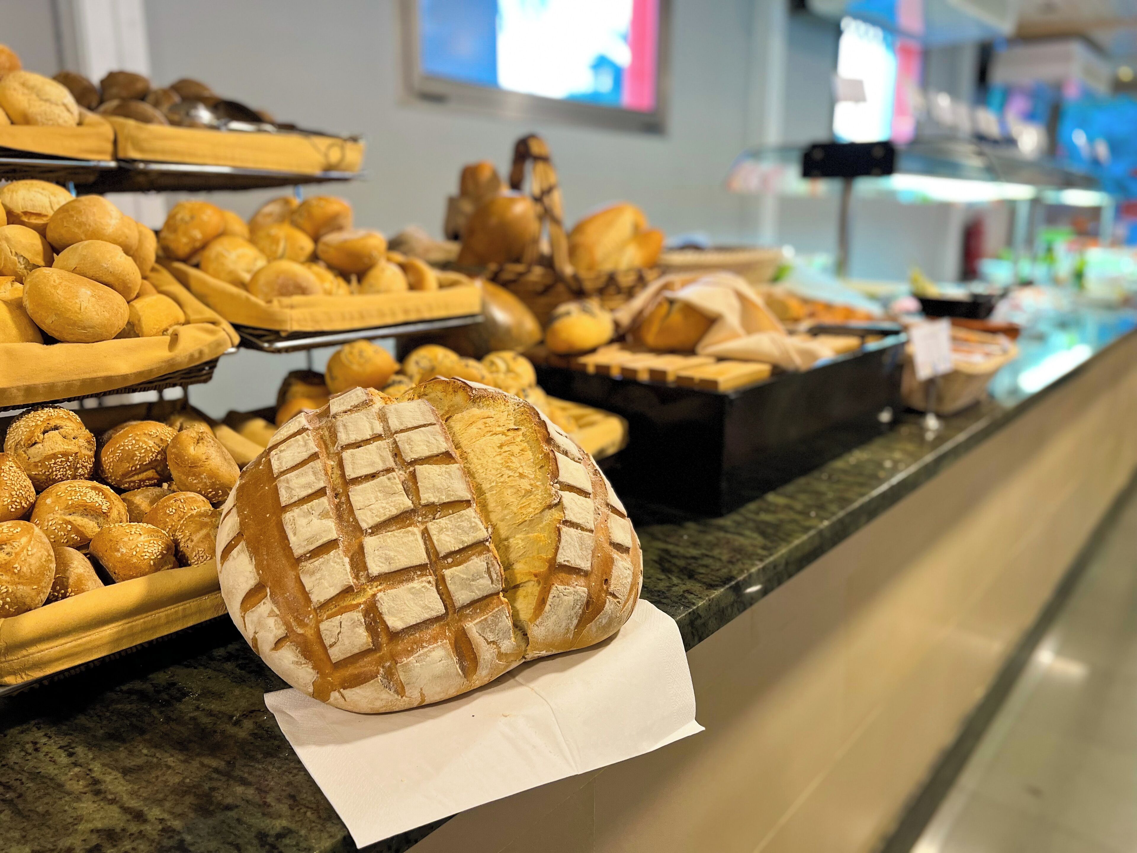 A bakery display with various breads and pastries.