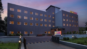 A modern building with a flat roof, multiple windows, and a sign reading "GINGER".
