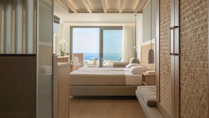 Una habitación de hotel moderna con una cama grande, un escritorio y vistas al mar.