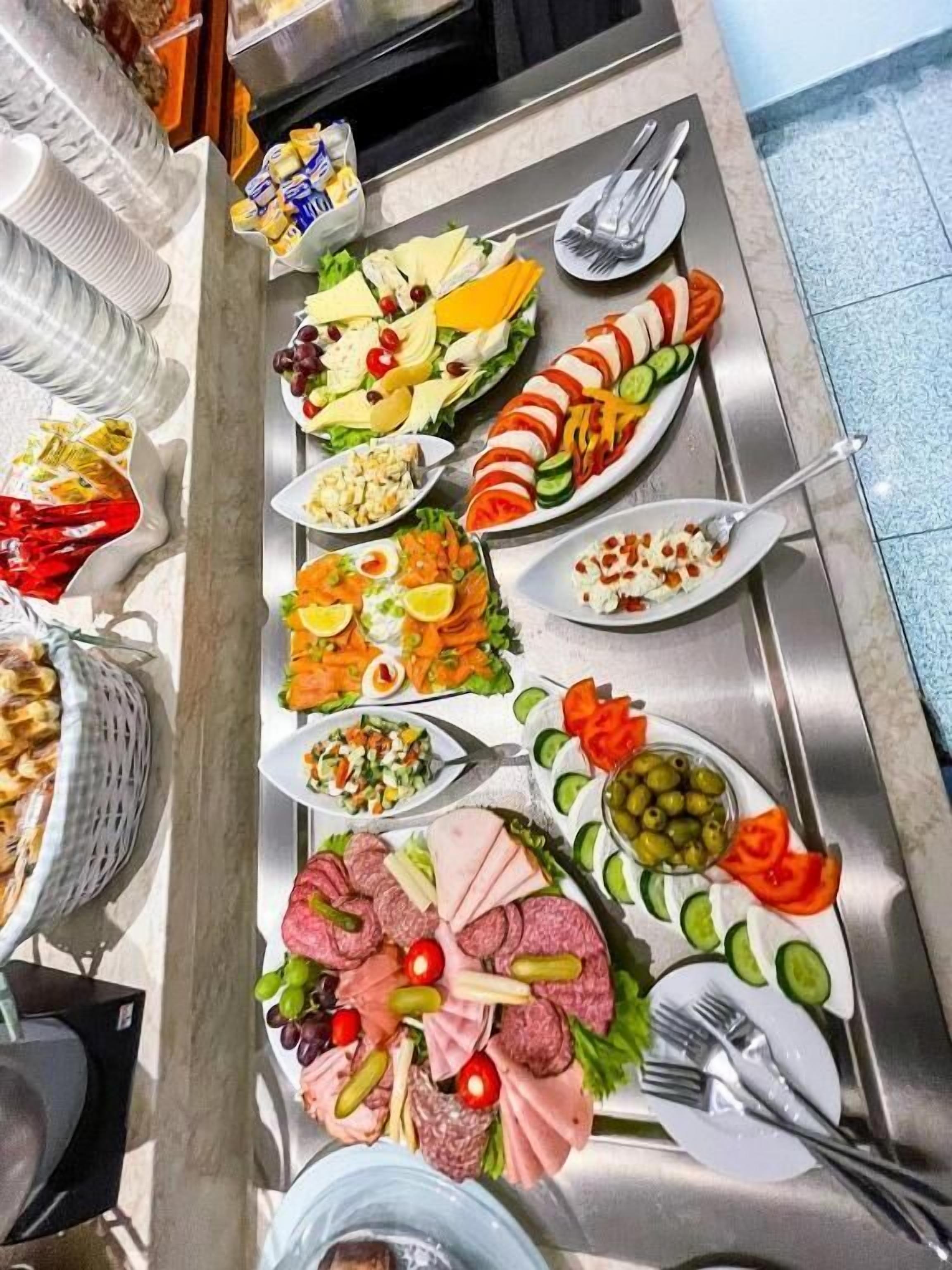 Una mesa de buffet con diversos alimentos y utensilios.