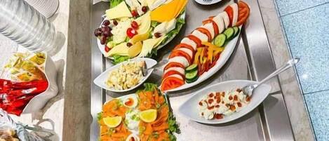 Una mesa de buffet con diversos alimentos y utensilios.