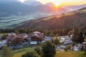 A mountain resort with multiple buildings, including a large lodge with a sloped roof and a smaller adjacent structure. - Natur & Wellnesshotel Höflehner (Haus)