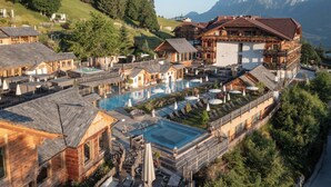 A resort with multiple buildings, a central pool, and mountainous views.