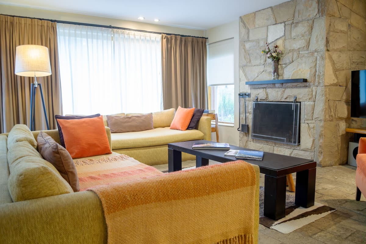 A living room with a sofa, coffee table, and a fireplace.
