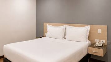 A modern bedroom with a bed, bedside tables, and a telephone.