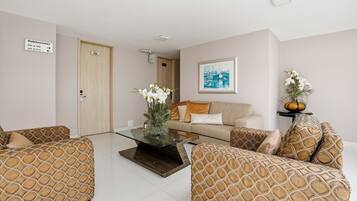 A modern living room with a sofa set, a coffee table, and a framed picture on the wall.