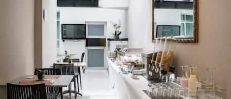 A modern kitchen with a central island, a dining area with chairs, and a large mirror on the wall.
