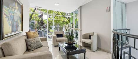 A modern interior with a sofa set, a coffee table, and a glass railing.