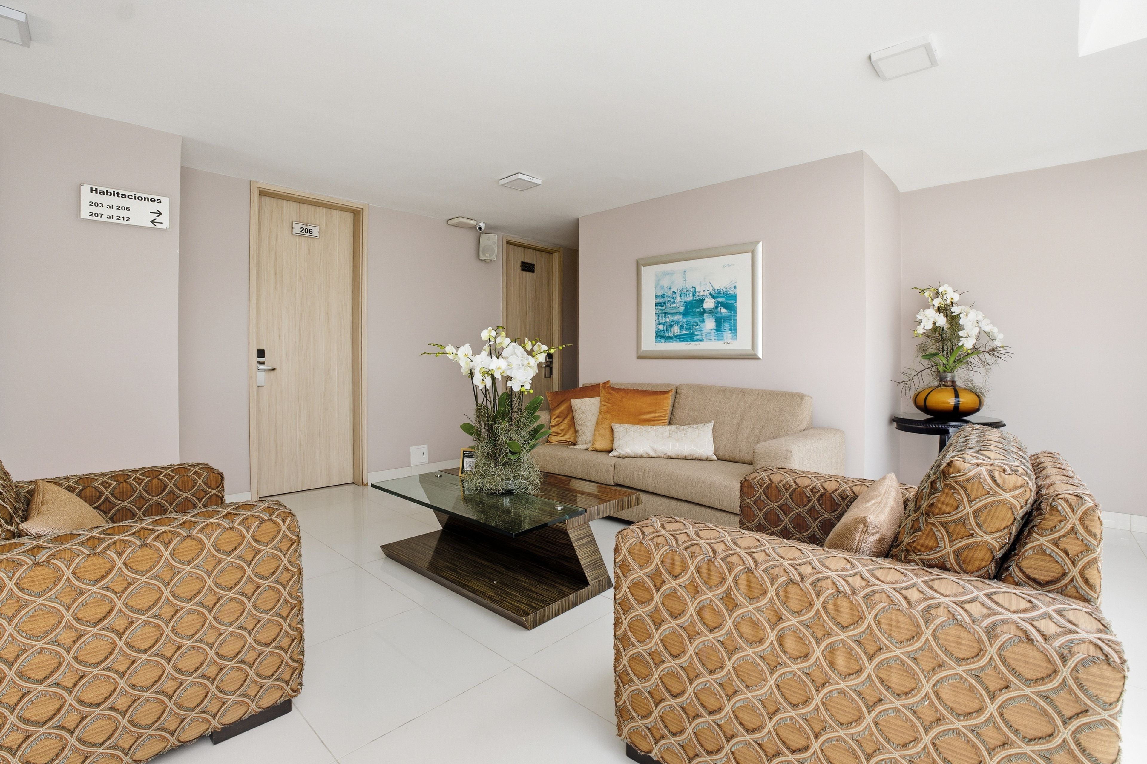 A modern living room with a sofa set, a coffee table, and a framed picture on the wall.