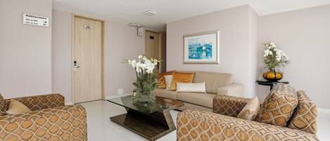 A modern living room with a sofa set, a coffee table, and a framed picture on the wall.