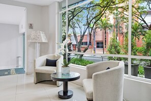 A modern hotel lobby with a seating area, a glass table, and a view of the outdoors. - Hotel Asturias Medellin (Medellín)