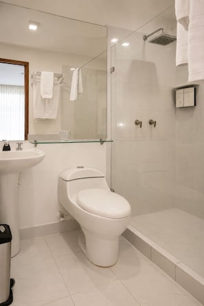 A modern bathroom with a toilet, a glass shower enclosure, and a bathtub. - Hotel Asturias Medellin (Medellín)
