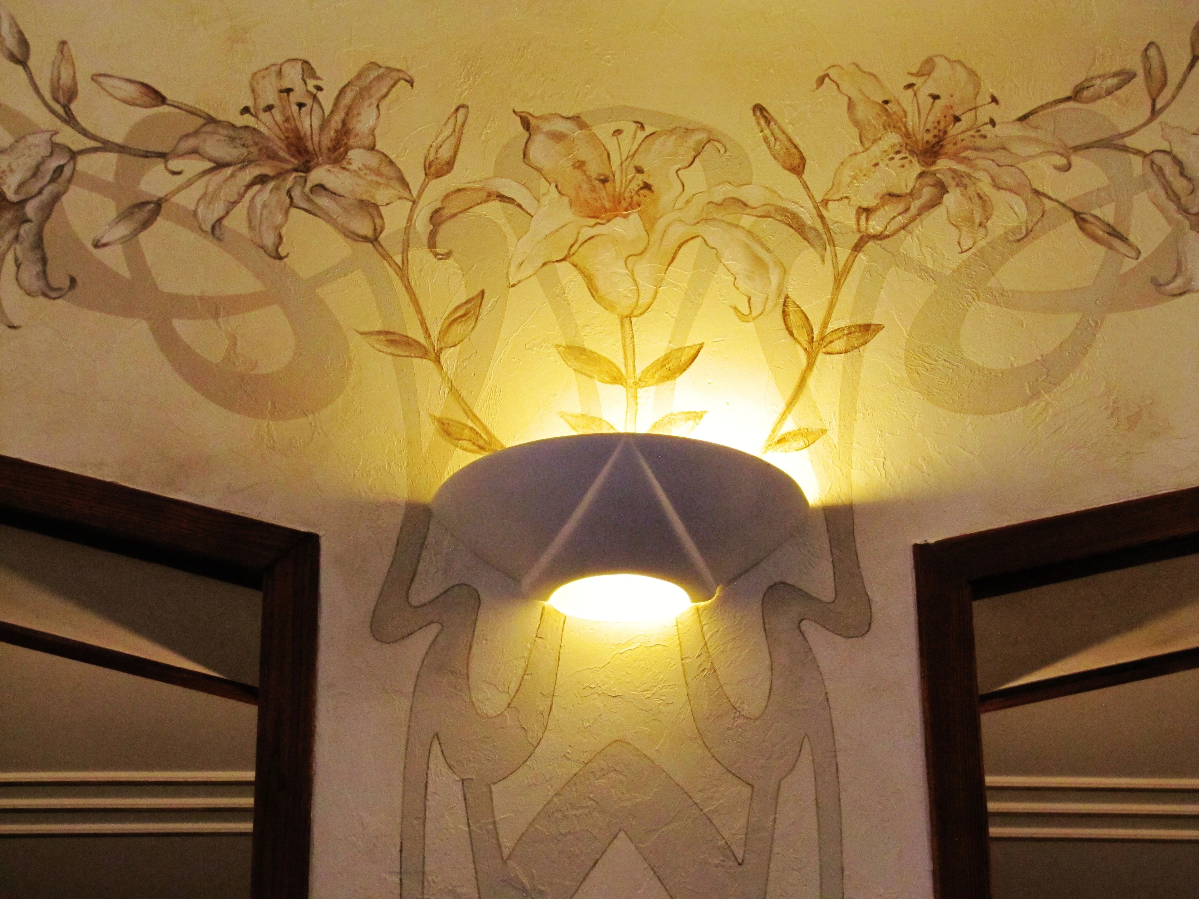 A wall with a floral mural and a light fixture.