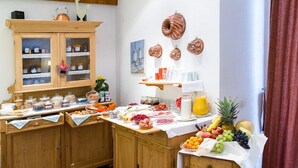 Um buffet de café da manhã com diversos alimentos e uma seleção de frutas.