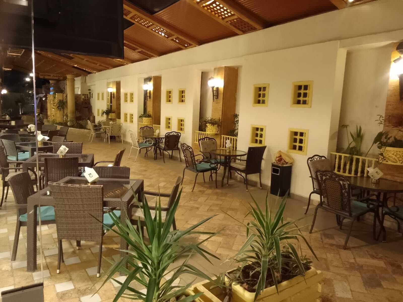 Un espace extérieur aménagé avec des meubles en osier et des plantes en pot.