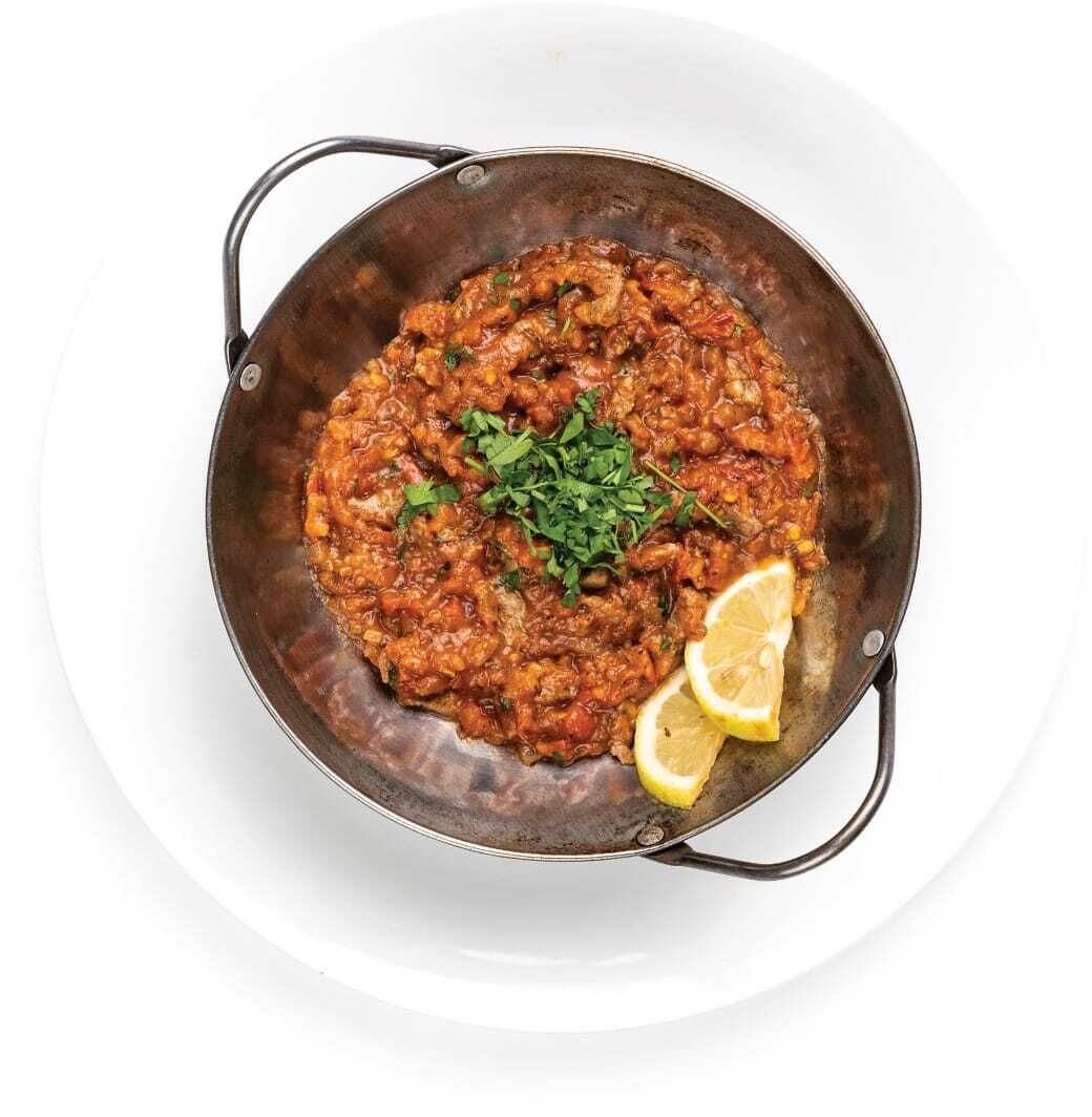 A dish in a metal pan on a white plate.