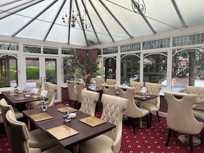 A conservatory with tables and chairs, large windows, and a chandelier. - The Chester House Hotel - Previously Chester Court Hotel (Chester)