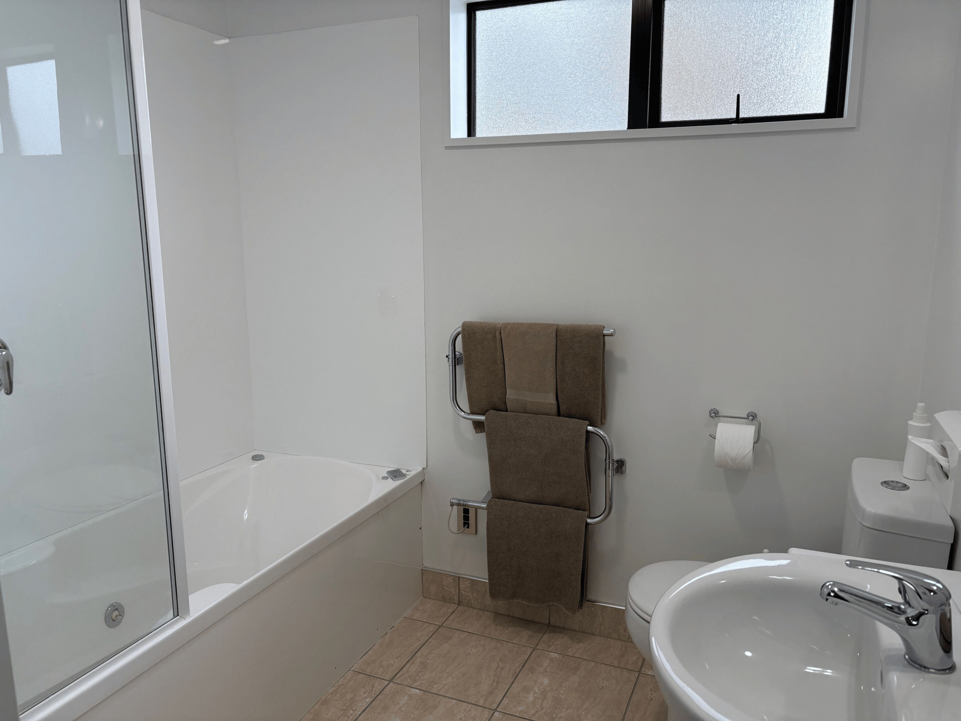 A bathroom with a bathtub, a toilet, and a sink.