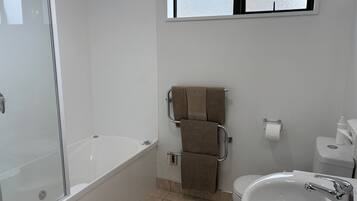 A bathroom with a bathtub, a toilet, and a sink.