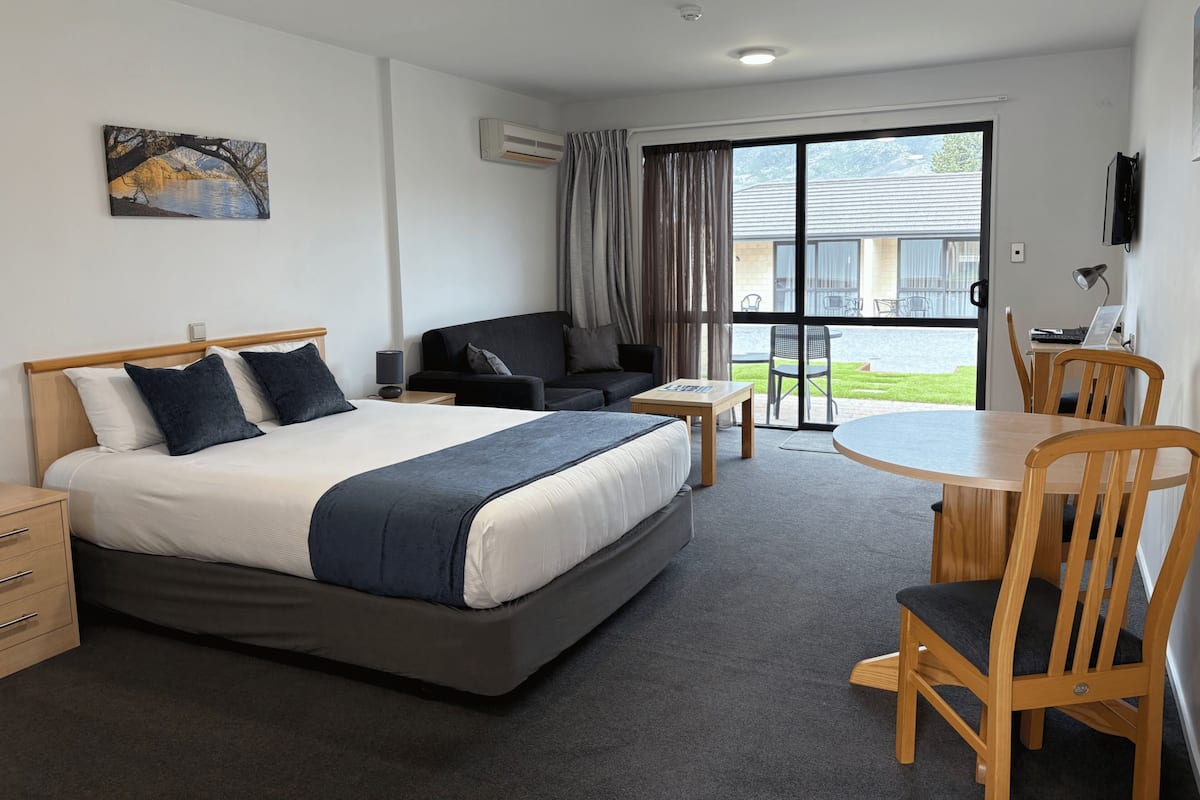 Una habitación de hotel con una cama, un sofá, una mesa y sillas.