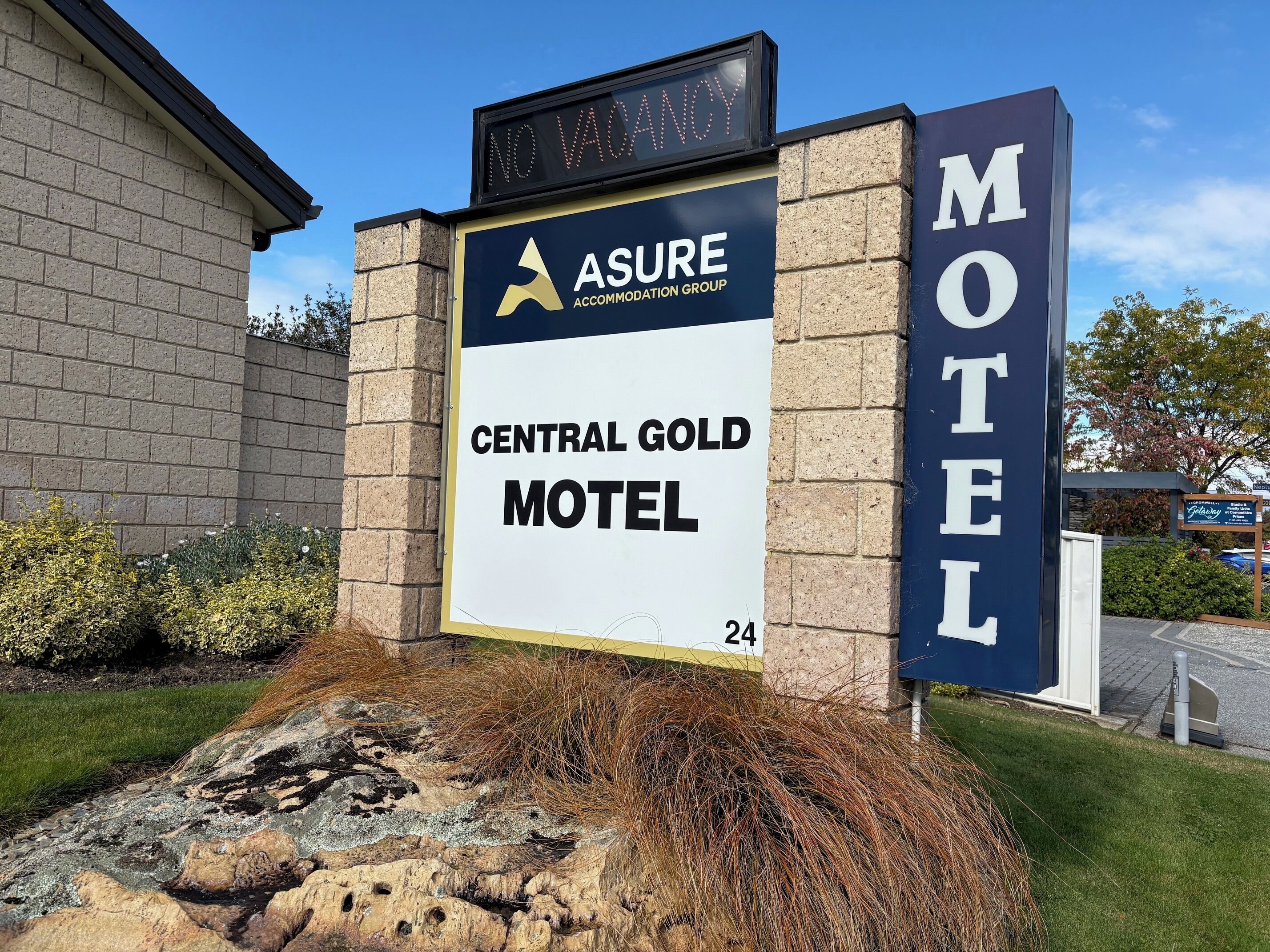 En skylt för ett motell med logotyperna för ”Asure Accommodation Group” och ”Central Gold Motel”.