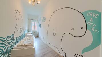 A bedroom with a bed, a window, and a wall with a whale illustration and the text "HAVE A NICE DAY!".