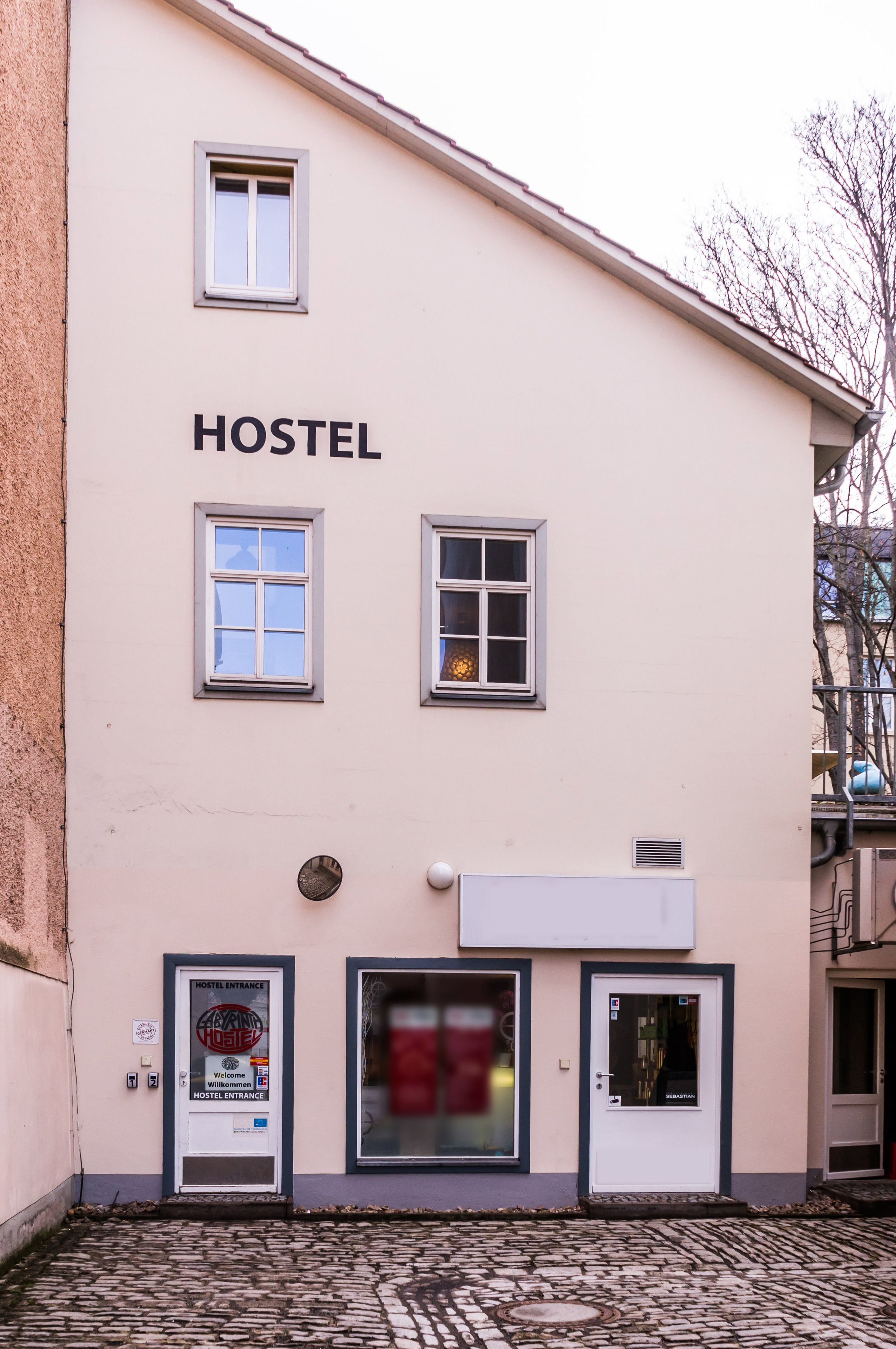 A hostel building with a sign reading "HOSTEL" above the entrance.