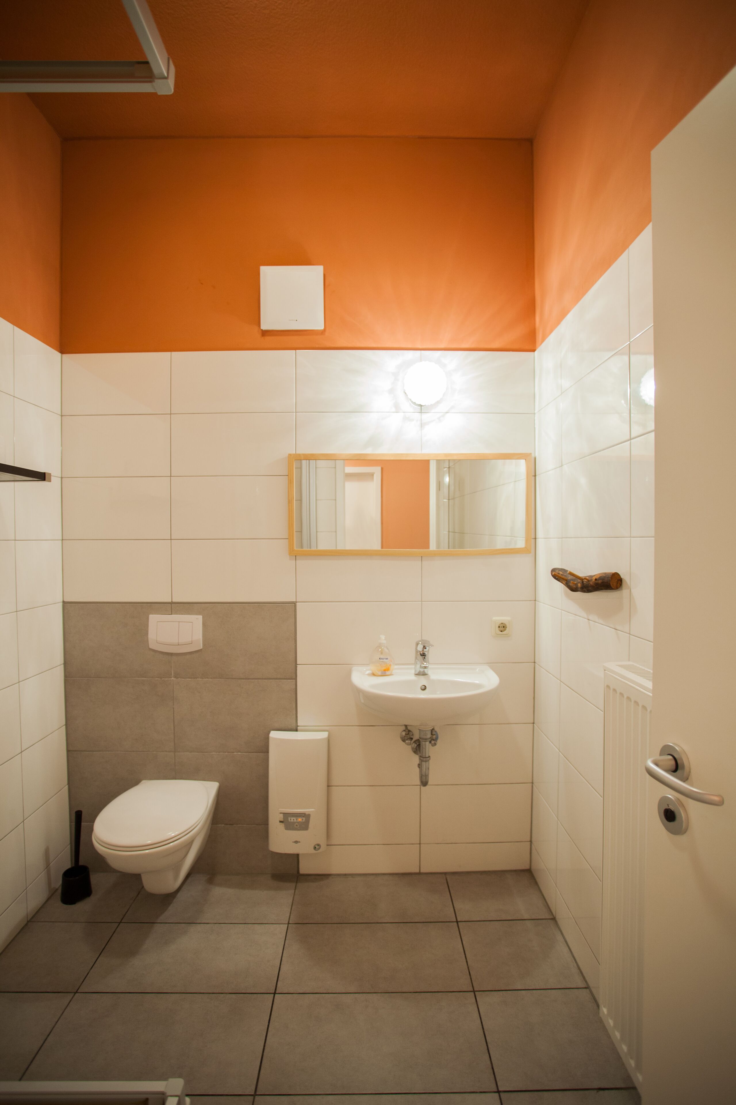 A small bathroom with a toilet, sink, and mirror.