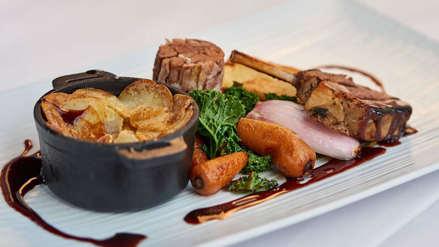 A plated dish with various meats and vegetables.