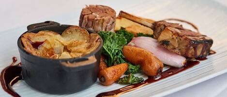 A plated dish with various meats and vegetables.