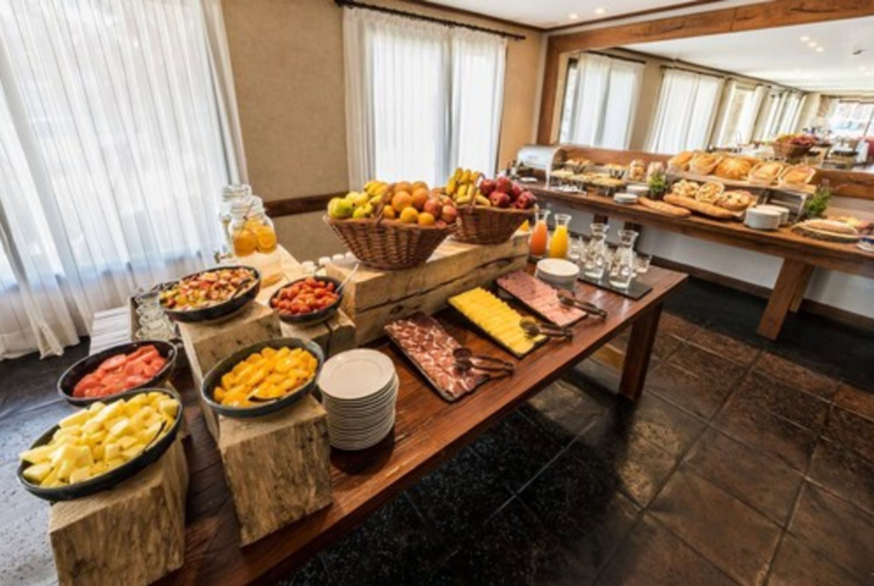 A buffet with various fruits, cheeses, and meats.