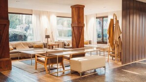 Ein geräumiges Wohnzimmer mit einem großen Couchtisch aus Holz, einer Couch und einem Staffelei.